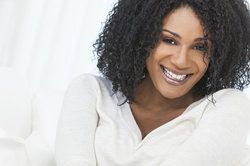 Laughing African American woman in white sweater